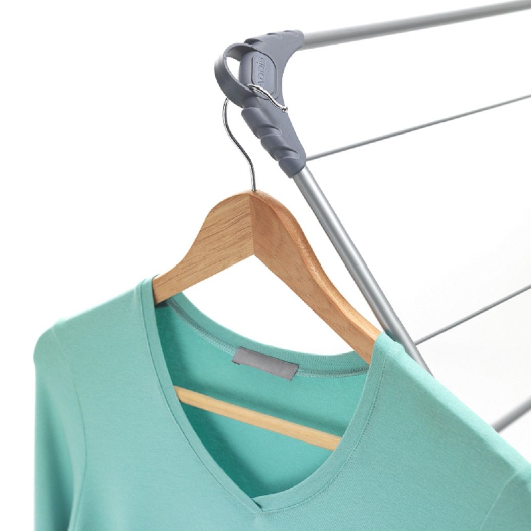 Aqua green shirt on a wooden hanger attached to a clothes drying rack.