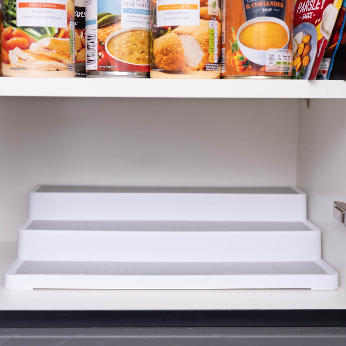 3 tier shelf organiser in kitchen cupboard, showing it fits perfectly.