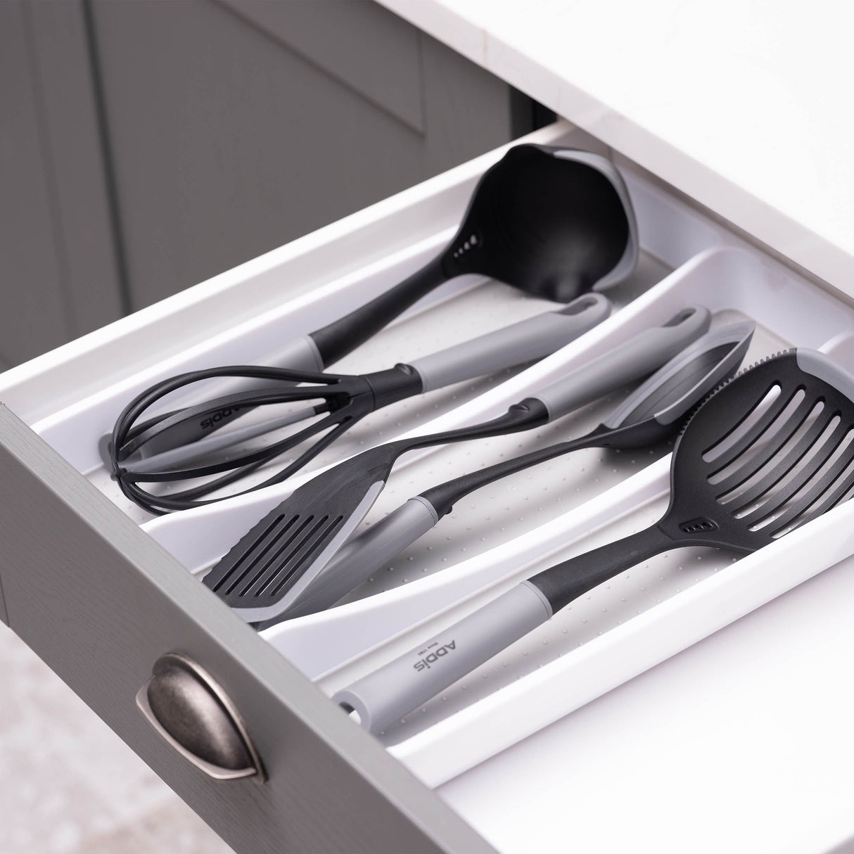 Set of black kitchen utensils organised in the drawer organiser