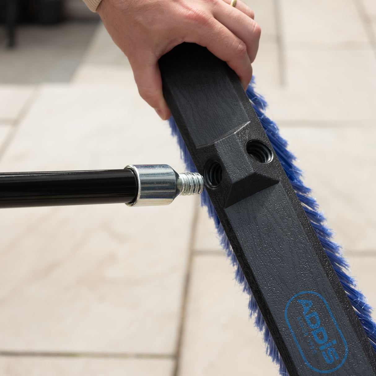 Broom pole handle being inserted into the brush head