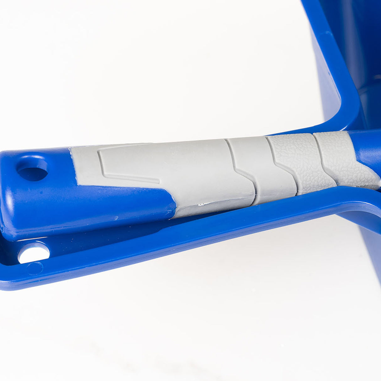 Close-up of a grey and blue dustpan and brush handle