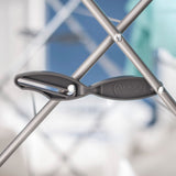 Close-up of a metal and plastic hinge on a clothes drying rack with a blurred background.