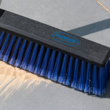 Brush head with blue bristles and black handle on a concrete surface, featuring the Addis brand logo.