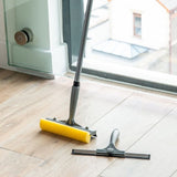 Cleaning tools on a wooden floor in front of a glass door.