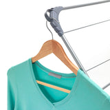 Aqua green shirt on a wooden hanger attached to a clothes drying rack.