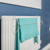 White radiator with a towel hanging on a rack against a blue wall.