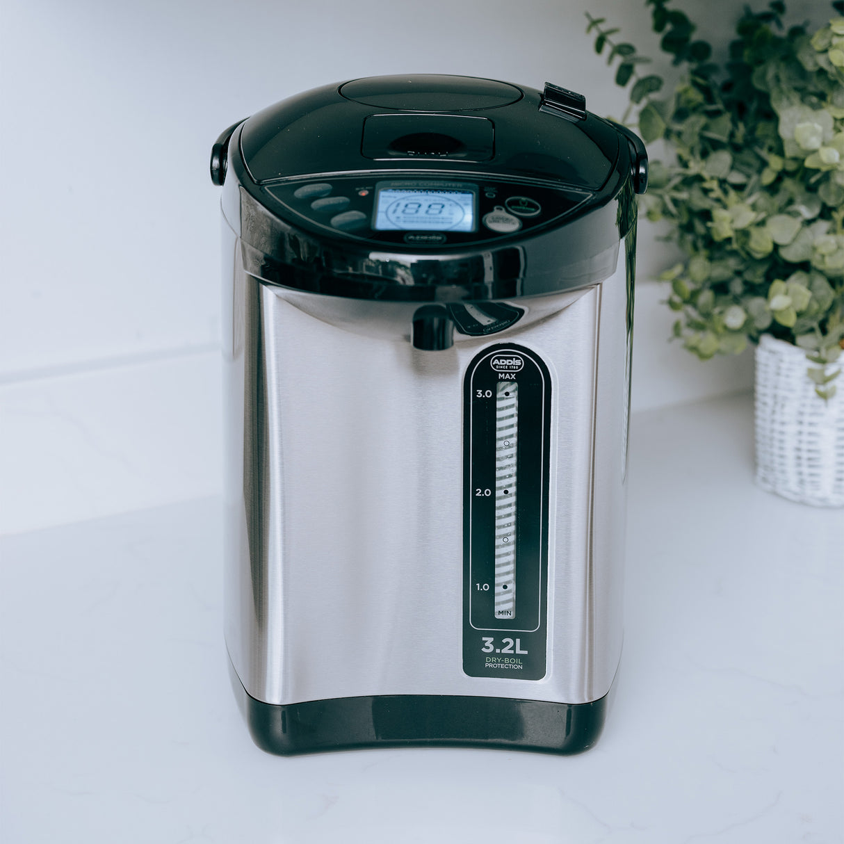 Stainless steel electric water dispenser on a white surface.